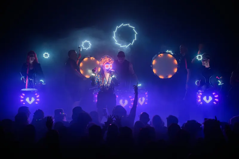 Flash Bang Brass performs amid blue and purple lights at Glastonbury.
